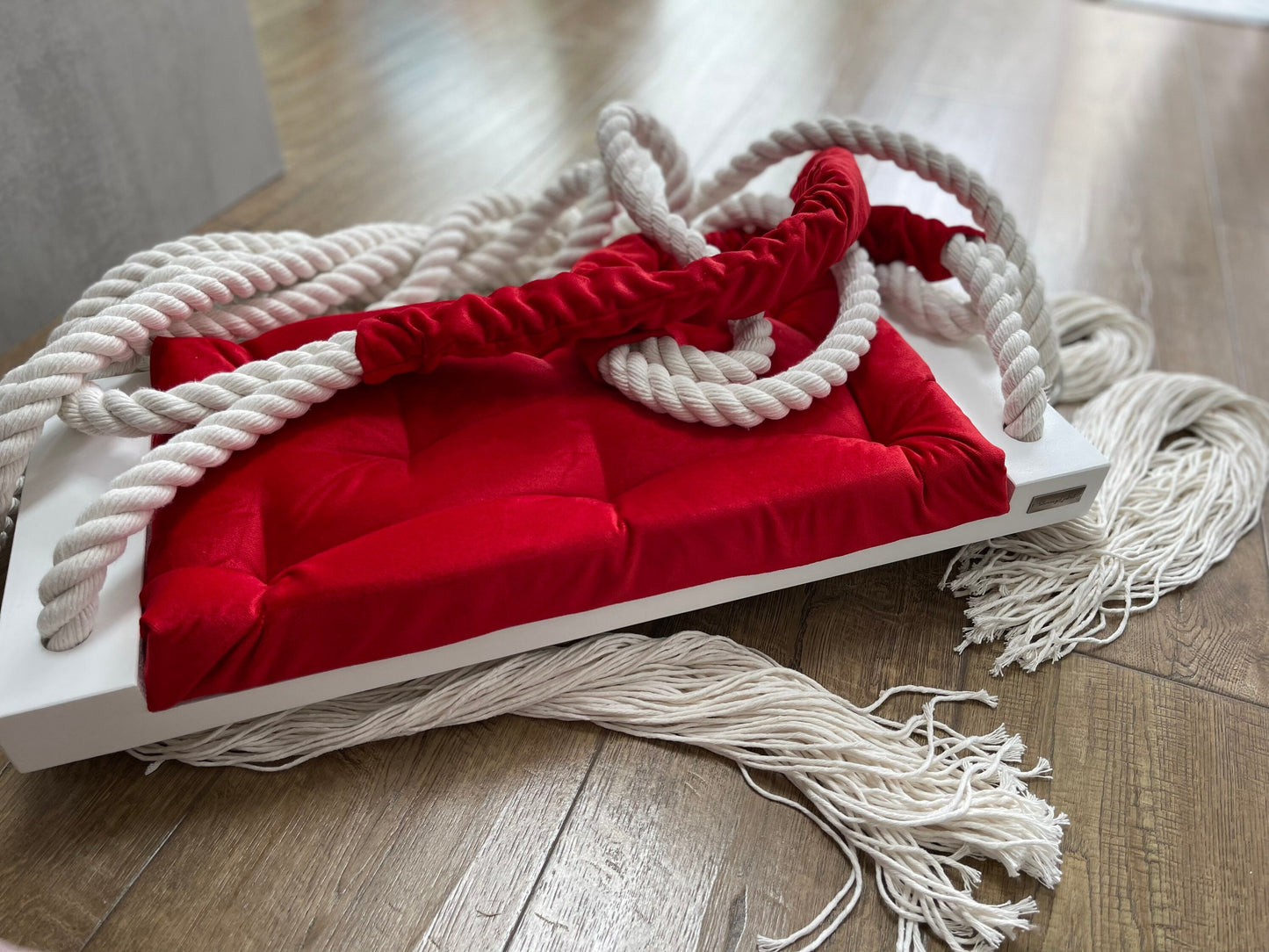 White wooden swing seat with coca - cola red pillow