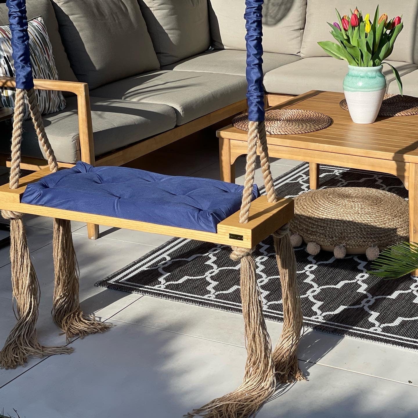 Light oak swing with cobalt blue pillow