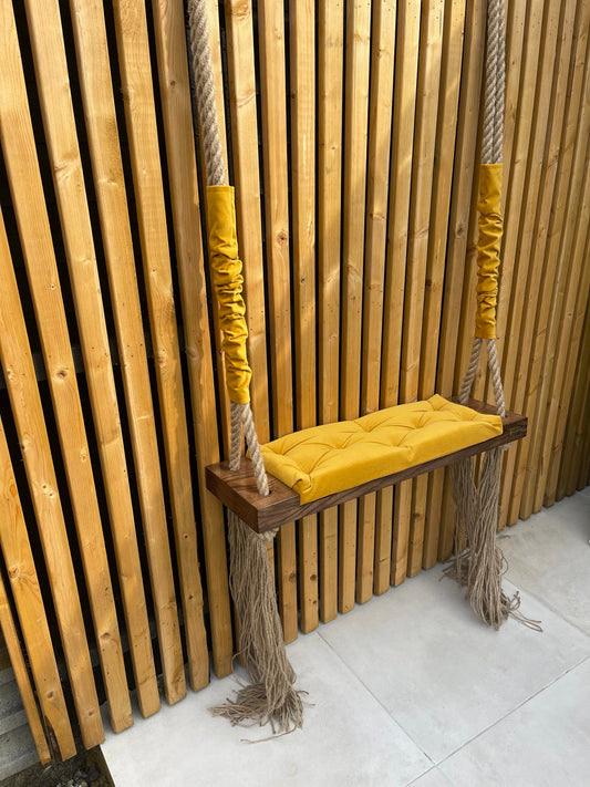 dark oak swing seat with mustard yellow quilted velvet cushion